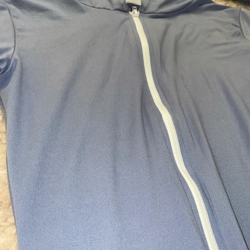Periwinkle body suit. Has a good and short sleeve. White zipper in the front.